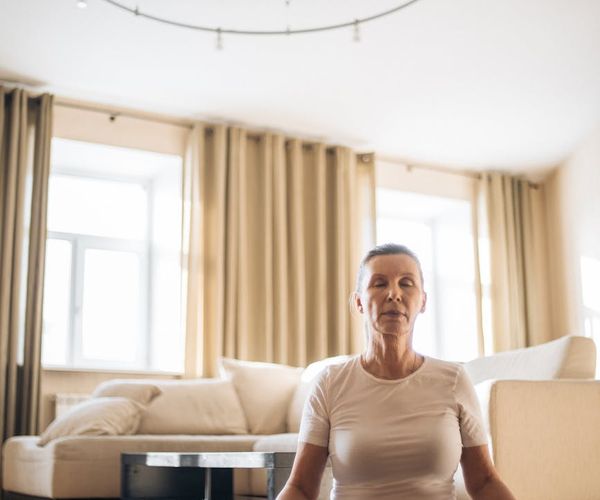 Close up of a person meditating in a peaceful room.